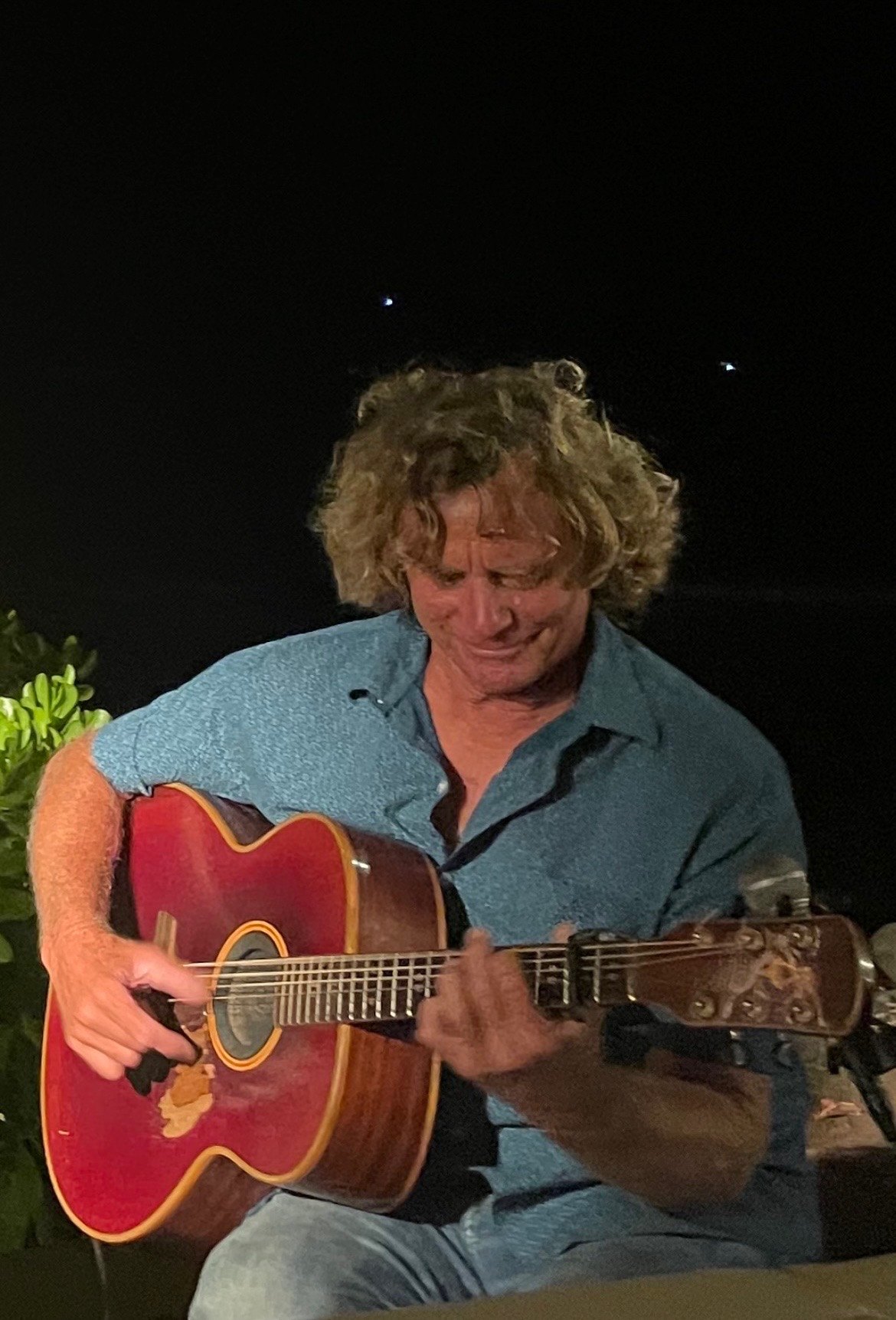 Shawn McLaughlin playing guitar outdoors at night.