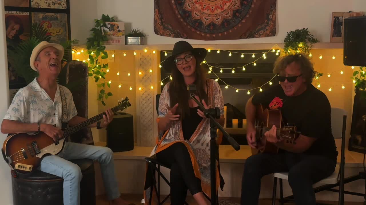 The Saltwater Soul Trio playing together under string lights on Maui.